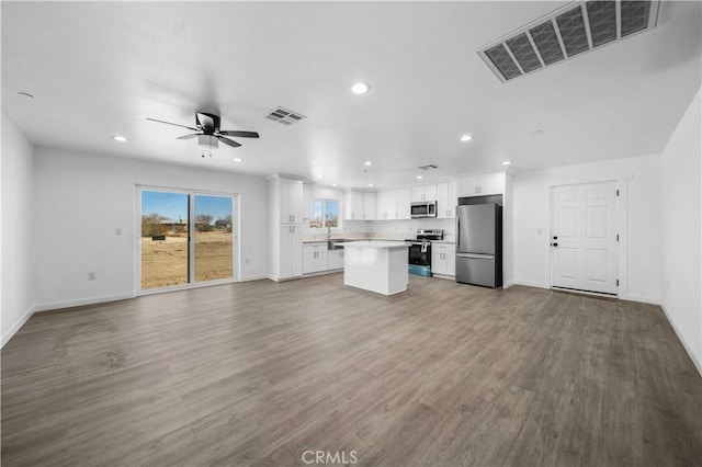 unfurnished living room featuring ceiling fan and hardwood / wood-style floors