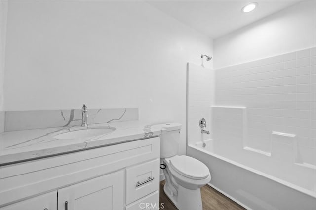 full bathroom with tub / shower combination, hardwood / wood-style floors, toilet, and vanity