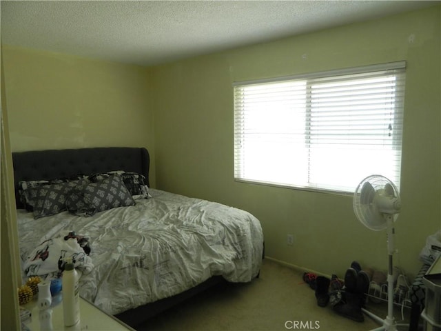 bedroom with a textured ceiling and carpet flooring