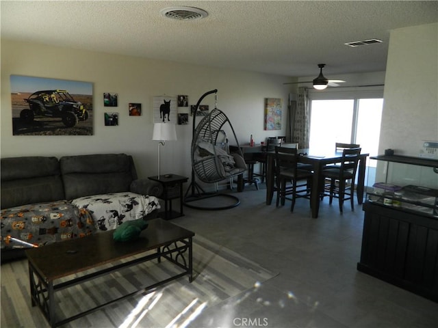 living room featuring a textured ceiling and ceiling fan