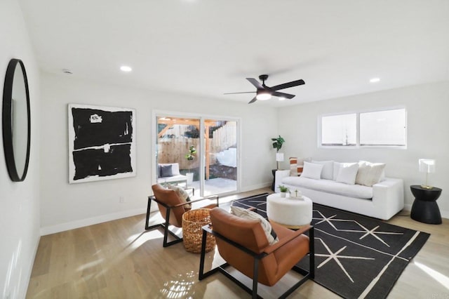 living room featuring ceiling fan and light hardwood / wood-style flooring