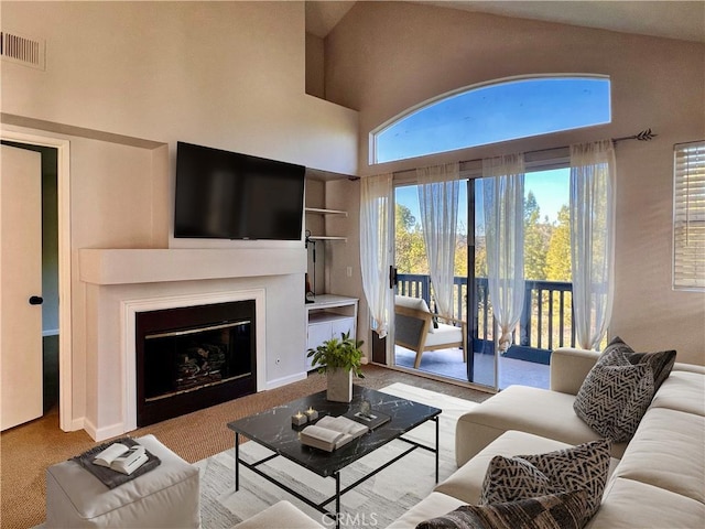 carpeted living room with a high ceiling