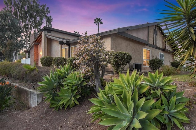 property exterior at dusk featuring central AC unit