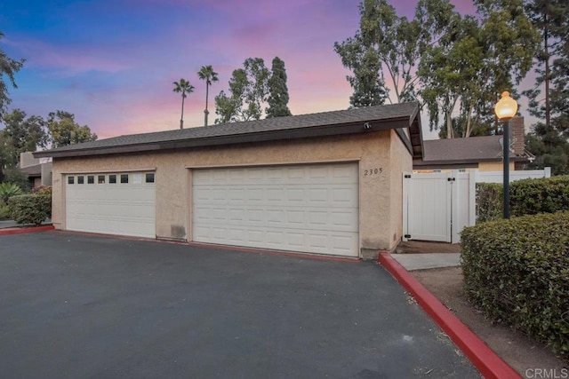 view of garage at dusk