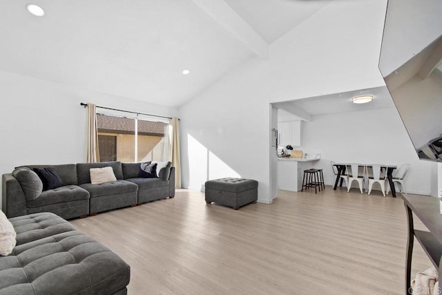 living room featuring light hardwood / wood-style floors, high vaulted ceiling, and beamed ceiling