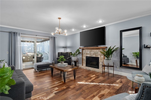 living room with a chandelier, hardwood / wood-style floors, a fireplace, and crown molding