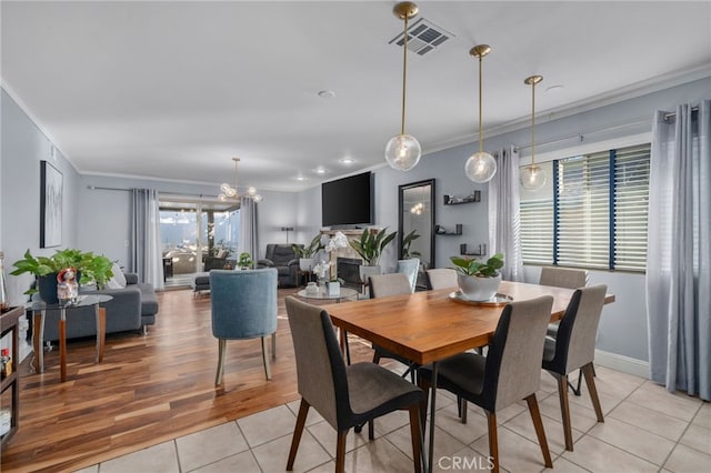 dining space featuring light tile patterned floors and ornamental molding