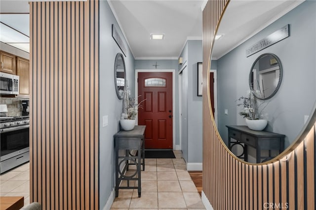 tiled entrance foyer featuring crown molding