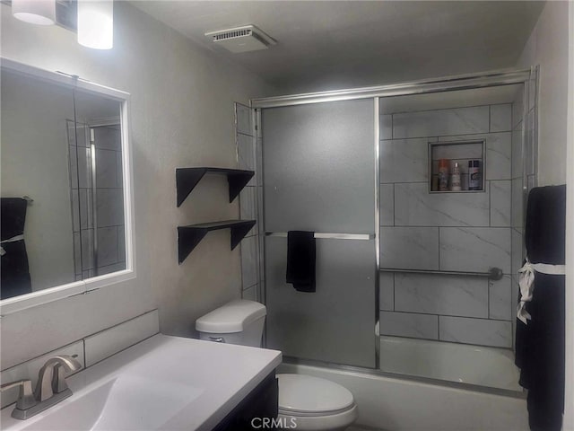 full bathroom with vanity, combined bath / shower with glass door, and toilet