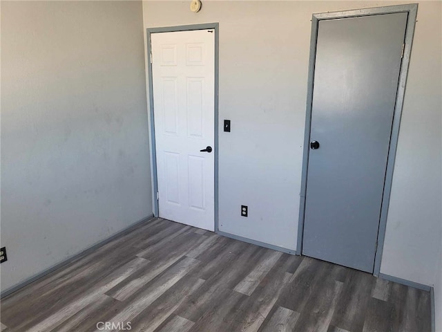 unfurnished bedroom featuring a closet and dark hardwood / wood-style floors