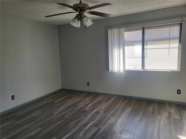 empty room featuring ceiling fan, dark wood-type flooring, and a textured ceiling