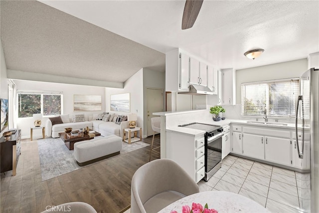 kitchen featuring stainless steel appliances, white cabinetry, sink, and kitchen peninsula