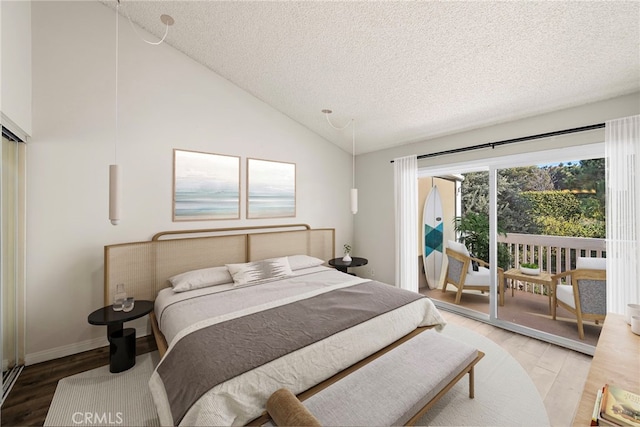 bedroom featuring lofted ceiling, hardwood / wood-style floors, a textured ceiling, and access to outside