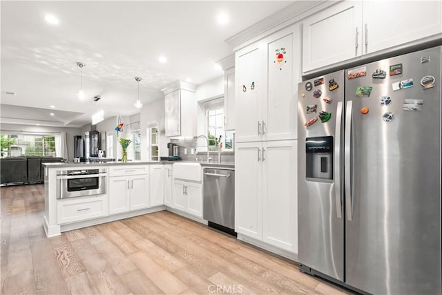 6770 Oak Ave, Arcadia, CA 91007 - kitchen featuring appliances with stainless steel finishes, open floor plan, a peninsula, white cabinetry, and light wood-type flooring