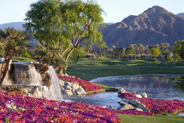 view of property's community with a lawn and a water and mountain view