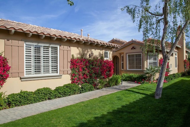 mediterranean / spanish-style house with a front yard