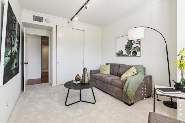 living room featuring light colored carpet, ornamental molding, and track lighting