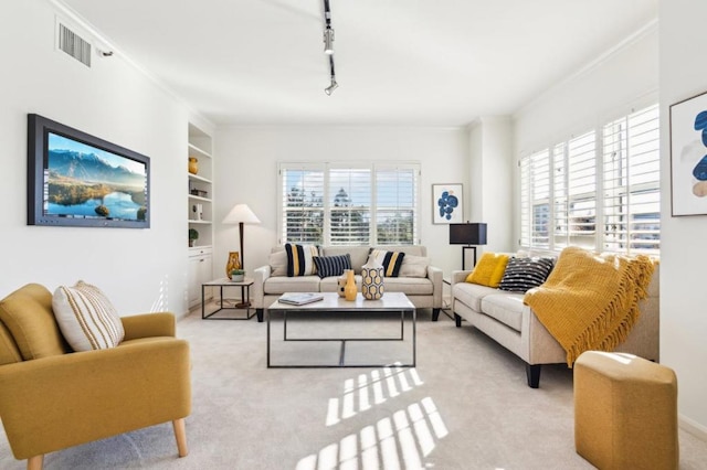 living room with built in shelves, light colored carpet, and rail lighting