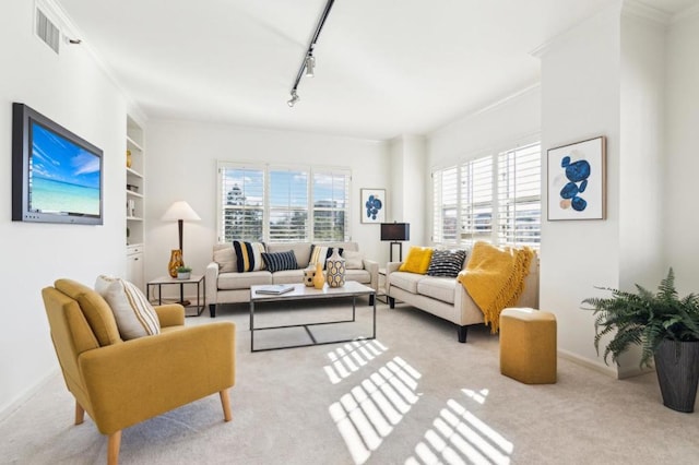 carpeted living room featuring ornamental molding and rail lighting