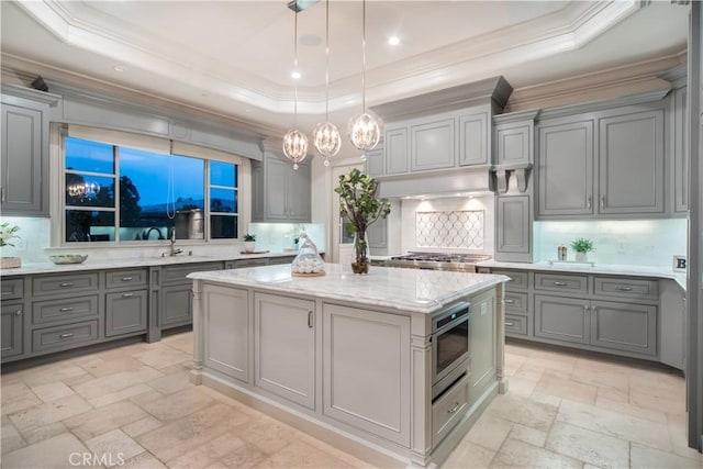 kitchen featuring backsplash, a center island, and a raised ceiling