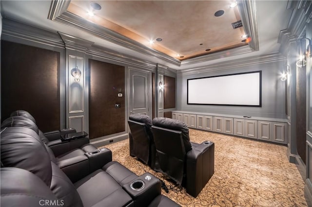 carpeted home theater room featuring crown molding and a tray ceiling