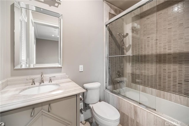 full bathroom featuring combined bath / shower with glass door, vanity, ornamental molding, and toilet