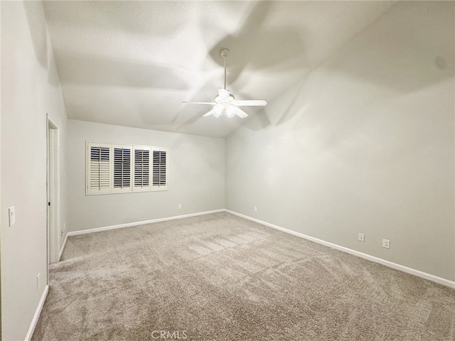 carpeted spare room featuring vaulted ceiling and ceiling fan