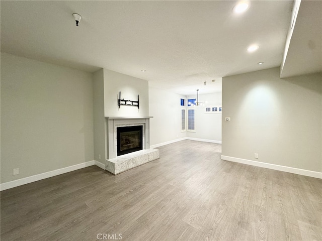 unfurnished living room with a premium fireplace and wood-type flooring