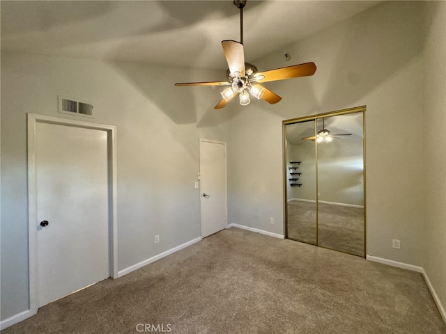 unfurnished bedroom with carpet flooring, visible vents, a ceiling fan, vaulted ceiling, and a closet