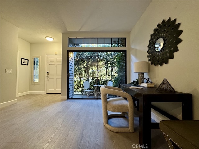 interior space with baseboards and wood finished floors