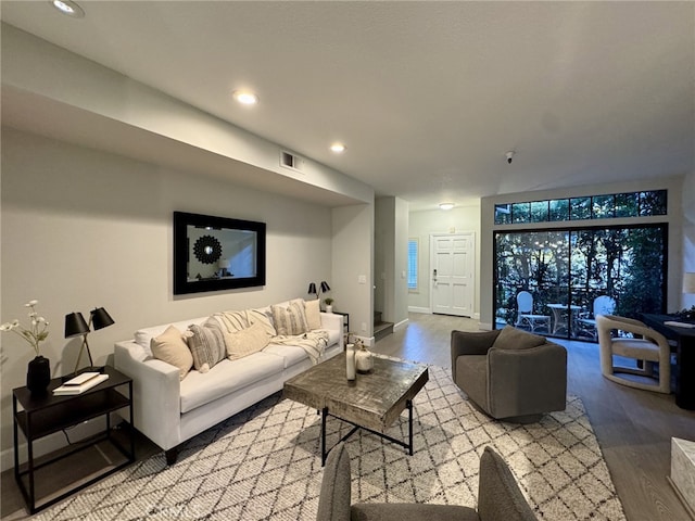 living room featuring light wood finished floors, baseboards, visible vents, and recessed lighting