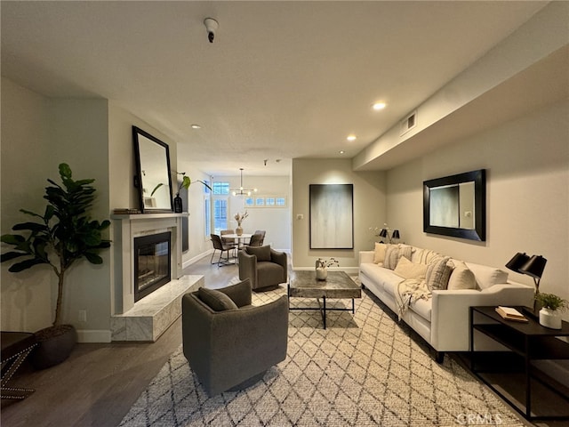 living area featuring recessed lighting, visible vents, a premium fireplace, wood finished floors, and baseboards