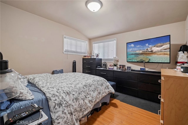 bedroom with hardwood / wood-style floors and lofted ceiling