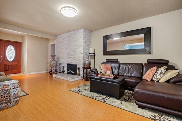 living room with hardwood / wood-style flooring and a stone fireplace