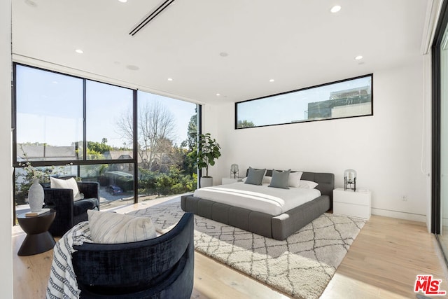 bedroom with light hardwood / wood-style flooring and floor to ceiling windows