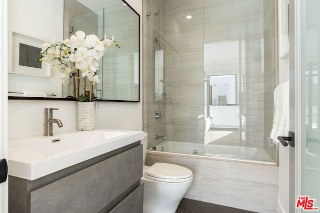 full bathroom with vanity, combined bath / shower with glass door, and toilet