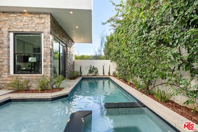 view of pool with an in ground hot tub