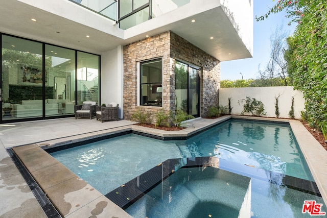 view of swimming pool featuring an in ground hot tub and a patio