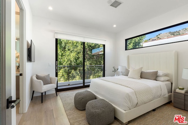 bedroom featuring access to exterior and light hardwood / wood-style flooring