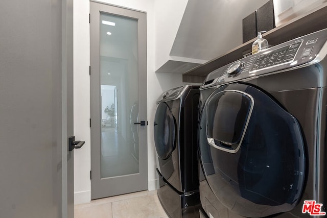 clothes washing area featuring light tile patterned floors and independent washer and dryer