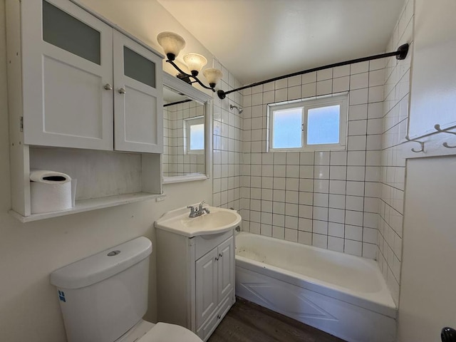 full bathroom featuring tiled shower / bath combo, hardwood / wood-style flooring, toilet, and vanity