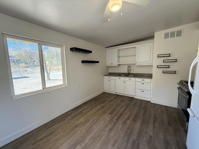 kitchen with sink, stainless steel range with electric stovetop, white cabinets, and dark hardwood / wood-style floors