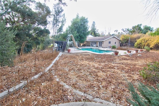 view of swimming pool featuring a patio and a water slide