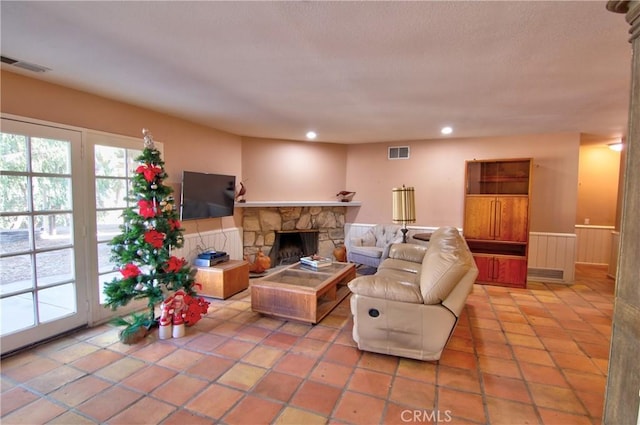 living room featuring light tile patterned floors and a stone fireplace