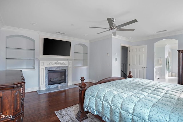 bedroom featuring a premium fireplace, crown molding, and dark hardwood / wood-style flooring