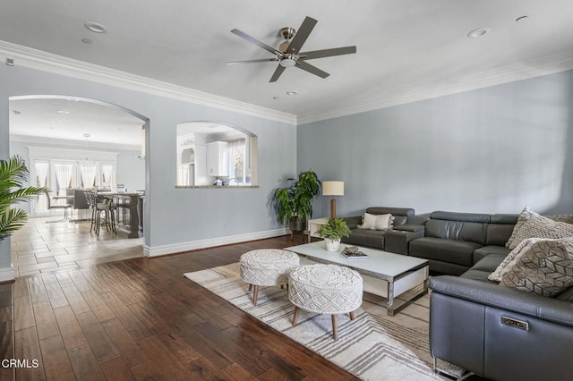 living room with ornamental molding, hardwood / wood-style floors, and ceiling fan