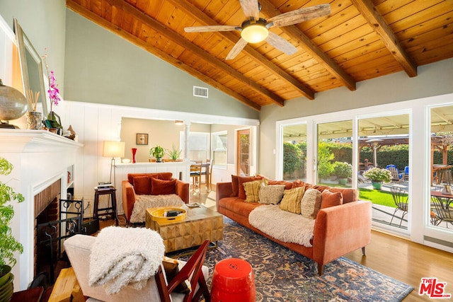 living room featuring beamed ceiling, high vaulted ceiling, light wood-type flooring, ceiling fan, and wooden ceiling