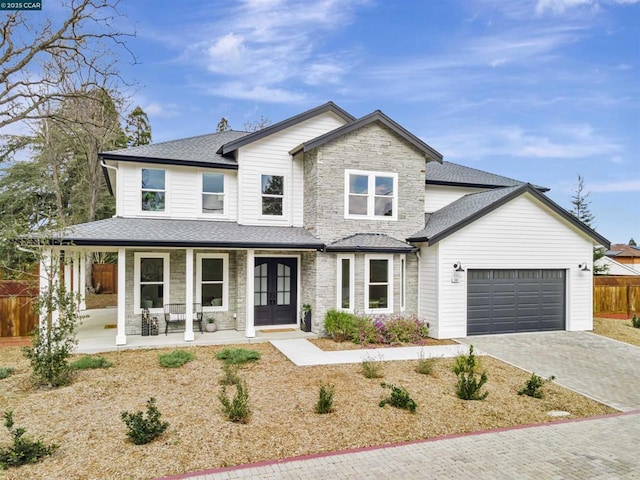 view of front of house with a garage, french doors, and covered porch