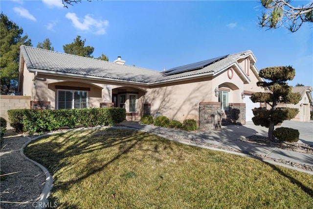 ranch-style home with solar panels and a front yard