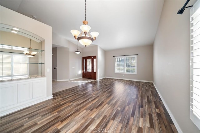 foyer entrance with dark hardwood / wood-style floors and a notable chandelier